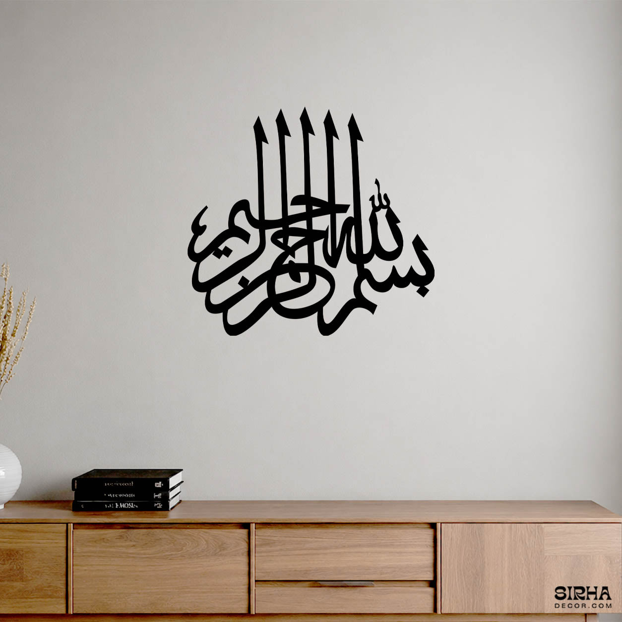 "A modern black laser-cut 3mm MDF Arabic calligraphy wall art piece of Bismillah ir-Rahman ir-Rahim displayed on a white wall by Sirha Decor."